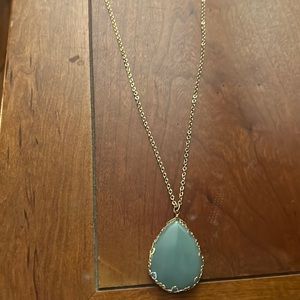 NWT greenish blue pendant surrounded in gold. Long gold chain. Costume jewelry.